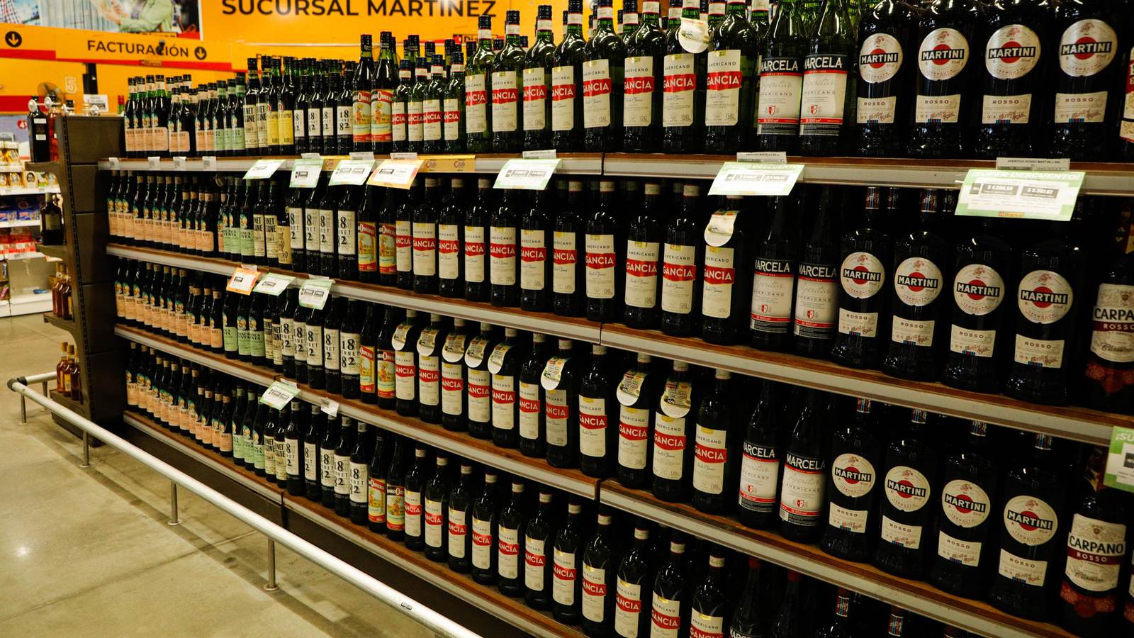 Pasillo de supermercado con las góndolas de bebidas en perspectiva y sus etiquetas de precio a la vista.